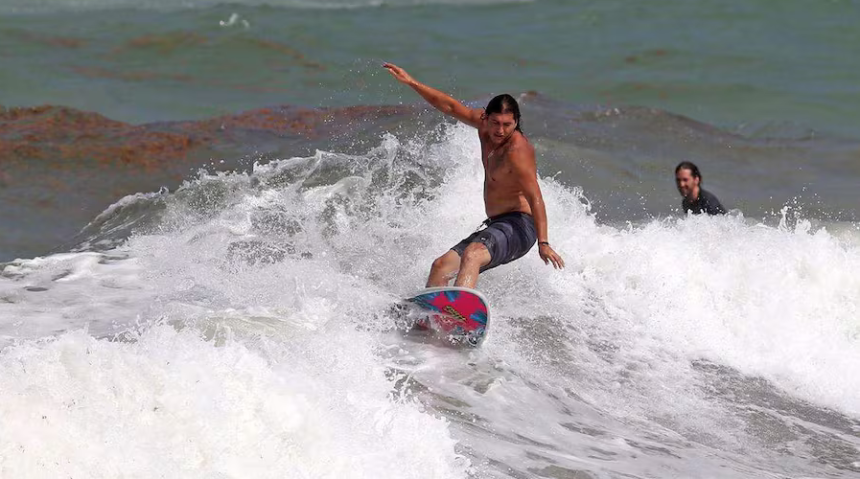Surfistas desafían el oleaje del huracán Erin en Stuart, Florida